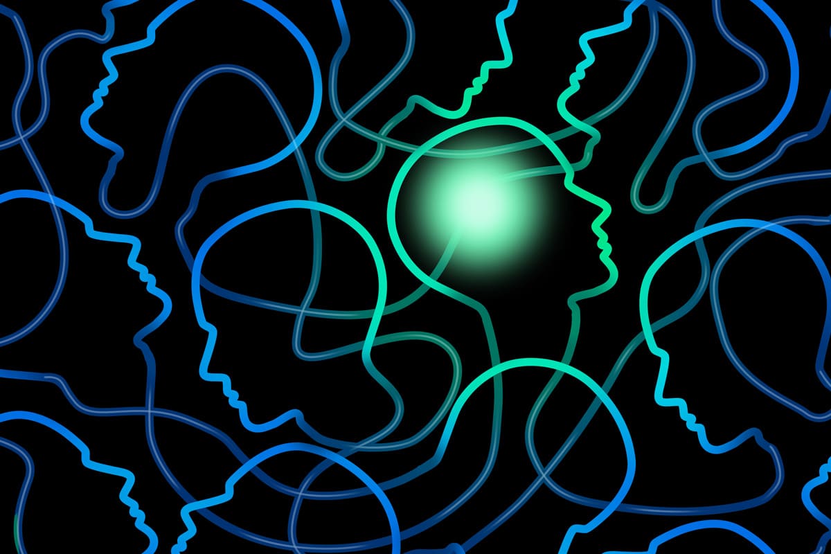 Learning organisation - light silhouettes of many heads in blue and green in space - netzwerk managementberatung coaching
